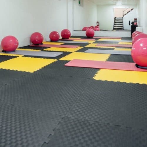 A modern, minimalist gym in Türkiye featuring yoga mats and colorful exercise balls for fitness activities.
