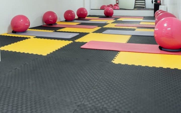 A modern, minimalist gym in Türkiye featuring yoga mats and colorful exercise balls for fitness activities.